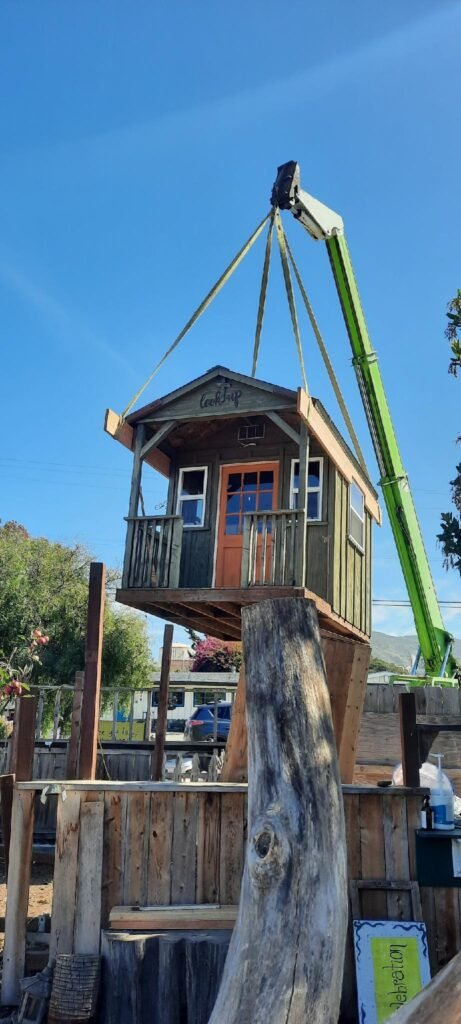 Crane lifting the beloved Wellspring playhouse onto a flatbed during the relocation process, marking the beginning of the school’s move to its new Templeton campus.