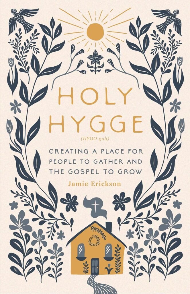 Book cover of “Holy Hygge” by Jamie Erickson, featuring floral illustrations, a golden sun, and a cozy house with smoke rising from the chimney. The subtitle reads “Creating a Place for People to Gather and the Gospel to Grow.”
