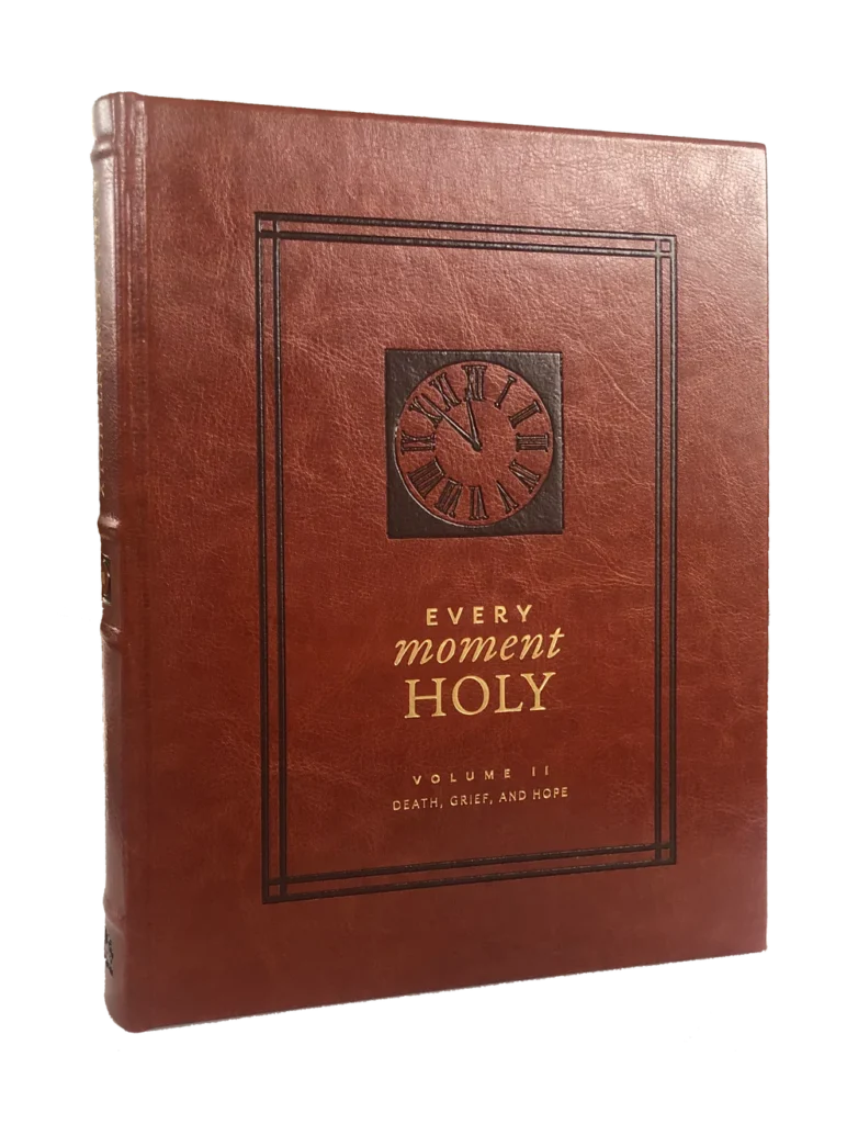 Leather-bound book titled “Every Moment Holy, Volume II: Death, Grief, and Hope” with embossed clock design and gold lettering on the cover.