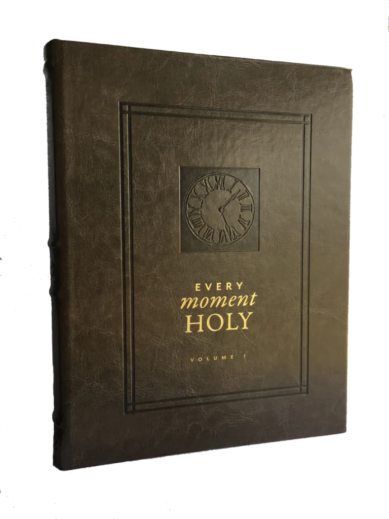 Leather-bound book titled “Every Moment Holy, Volume I” with embossed clock design and gold lettering on the cover.