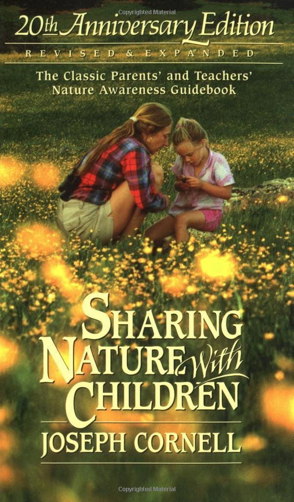 Book cover of Sharing Nature with Children by Joseph Cornell, 20th Anniversary Edition. The image shows a woman and young girl sitting together in a sunny field of wildflowers, looking closely at something in the child’s hands, with large yellow title text overlaid.