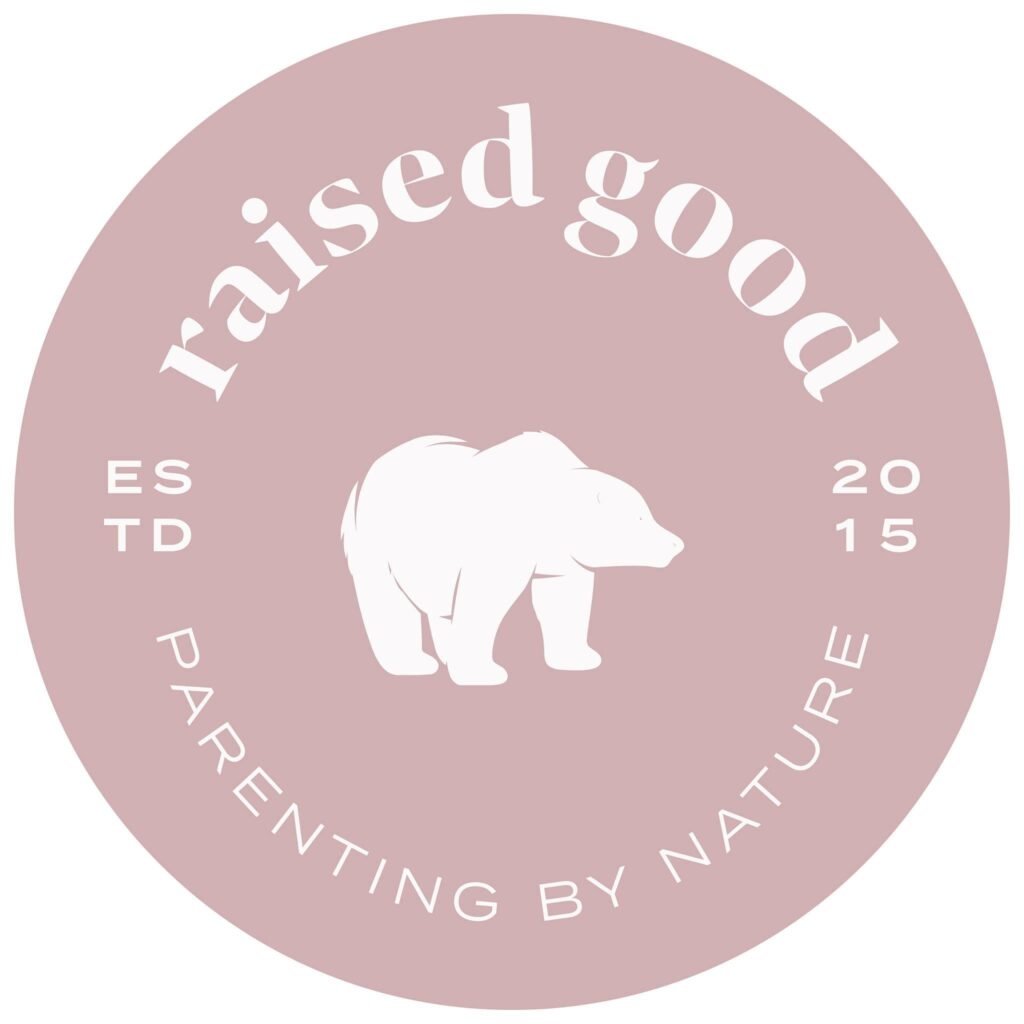 Circular blush-pink logo for Raised Good with a white silhouette of a bear in the center, and curved text reading ‘raised good’ and ‘parenting by nature,’ along with ‘ESTD 2015’ on either side.